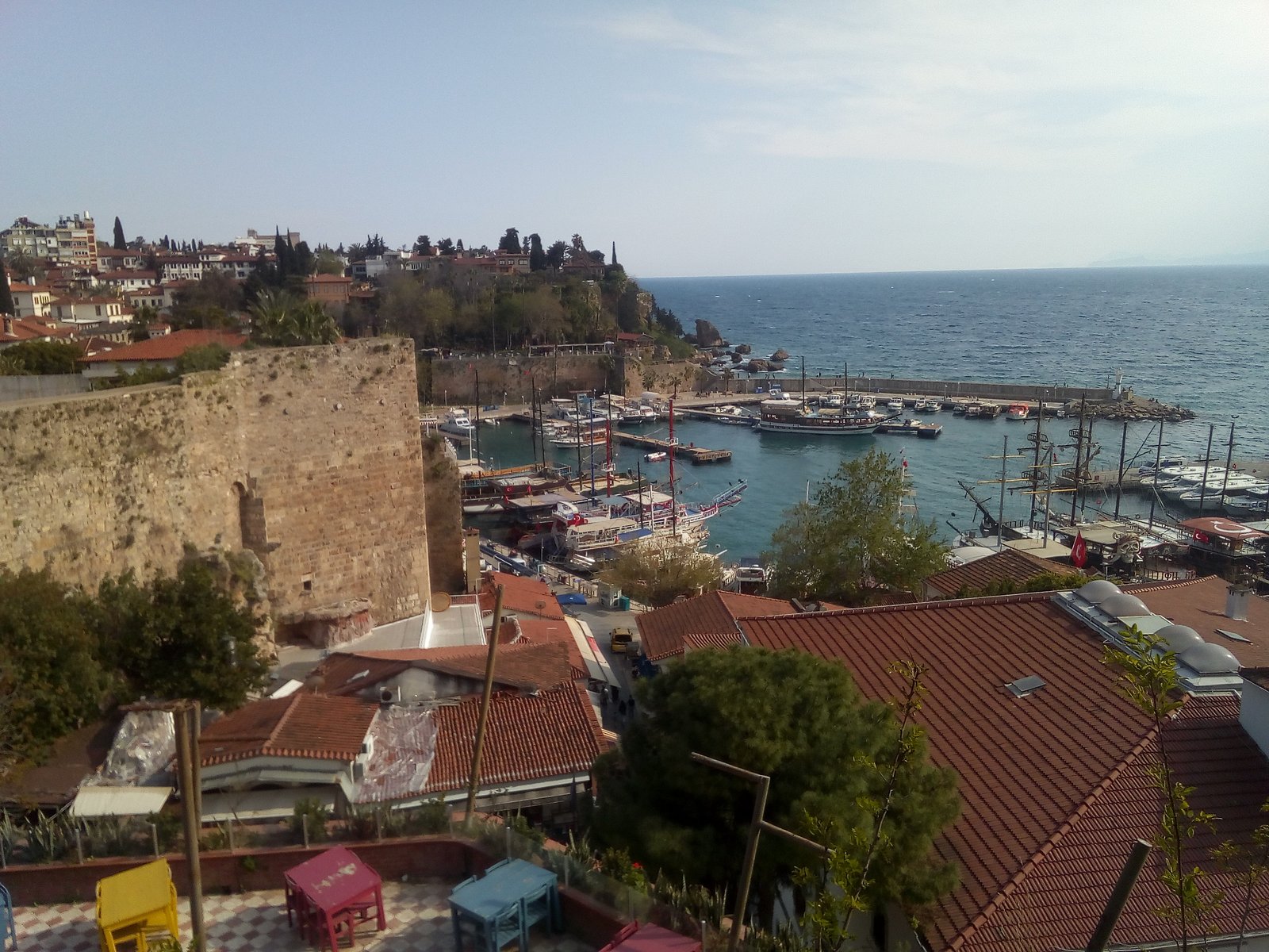 Boats in Kaleiçi's old harbour below the city walls and red-roofed houses