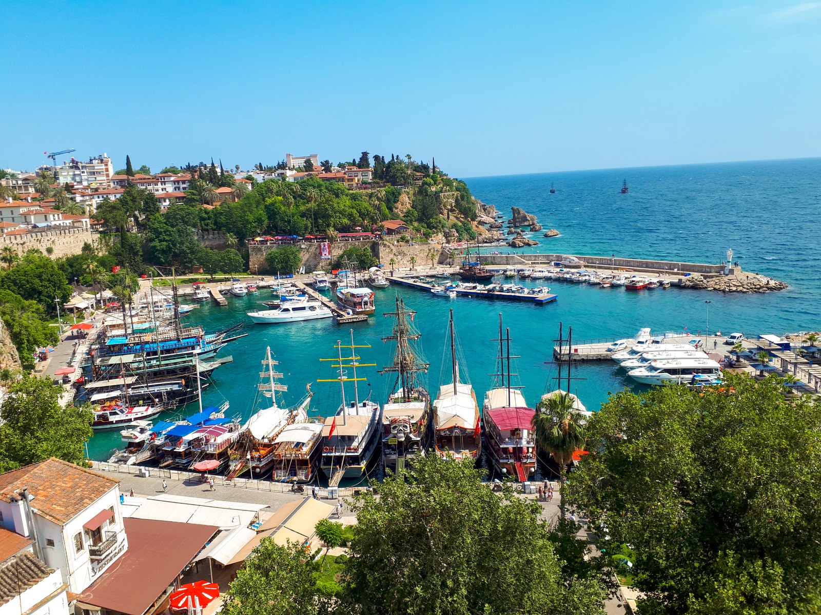 Boats in Antalya's Kaleiçi marina below the old-town houses and cliffs